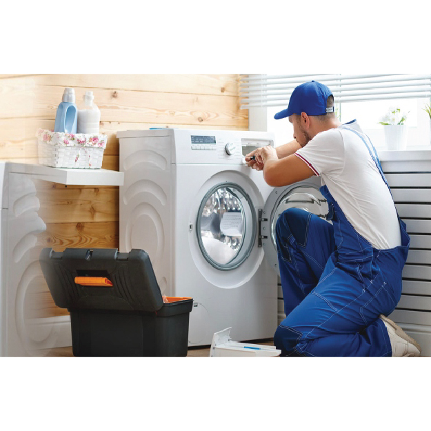 Technician working on a dryer in a laundry room.