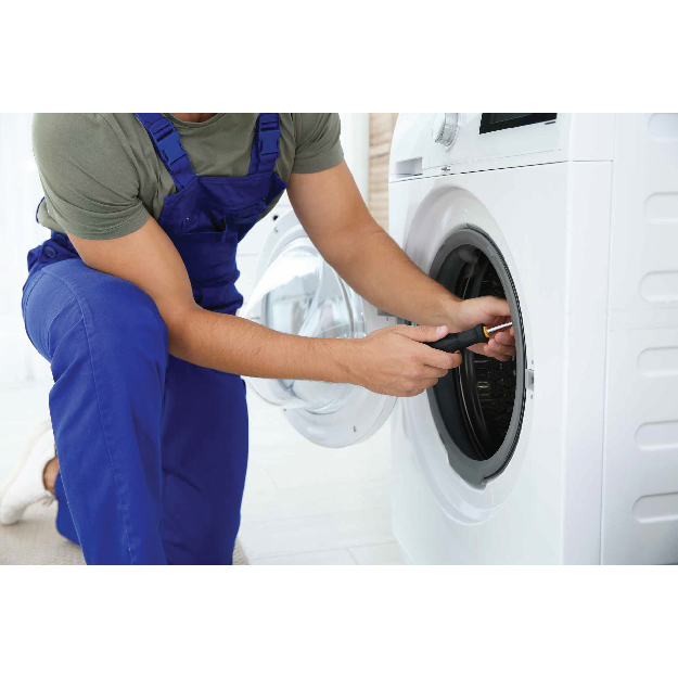 Technician repairing a washing machine in a laundry room
